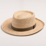 Natural colored straw hat with a brown band on a light beige background