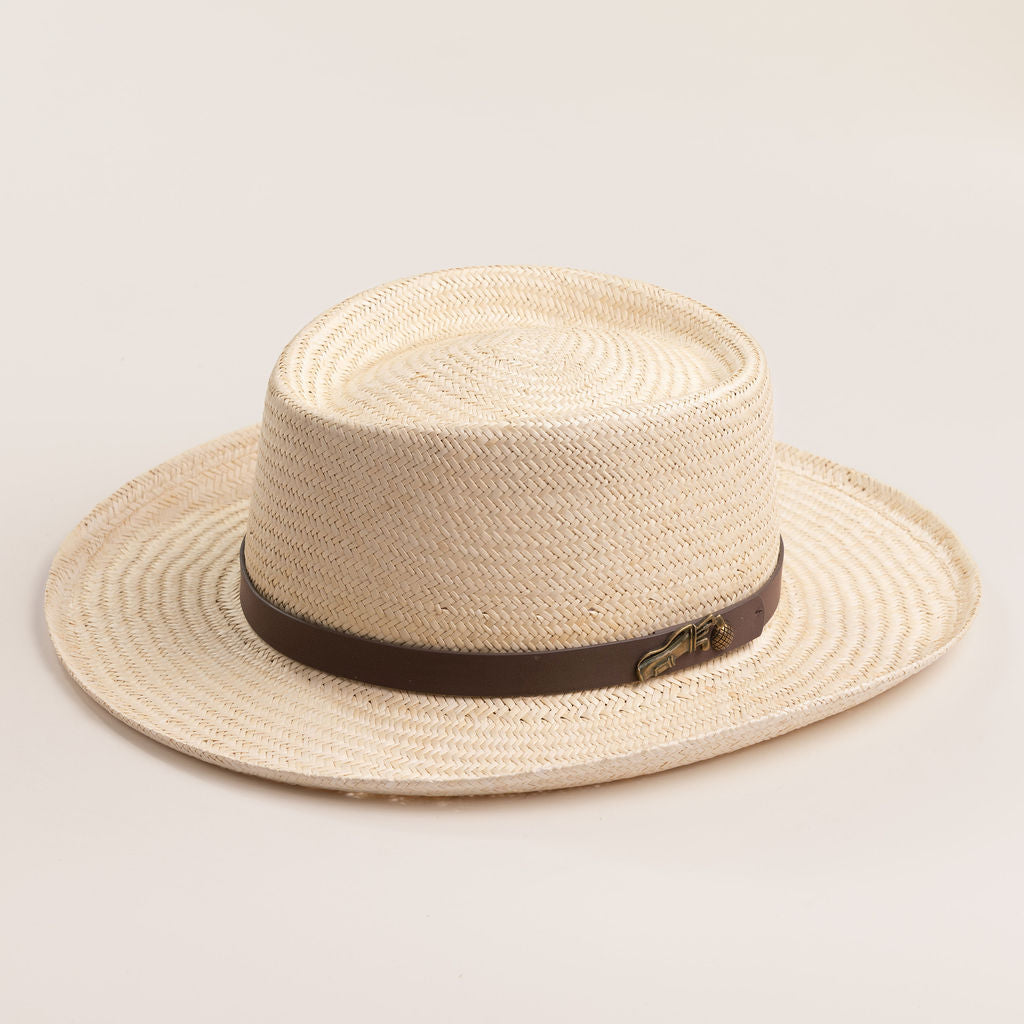 Natural colored straw hat with a brown band on a light beige background
