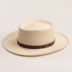 Natural colored straw hat with a brown band on a light beige background