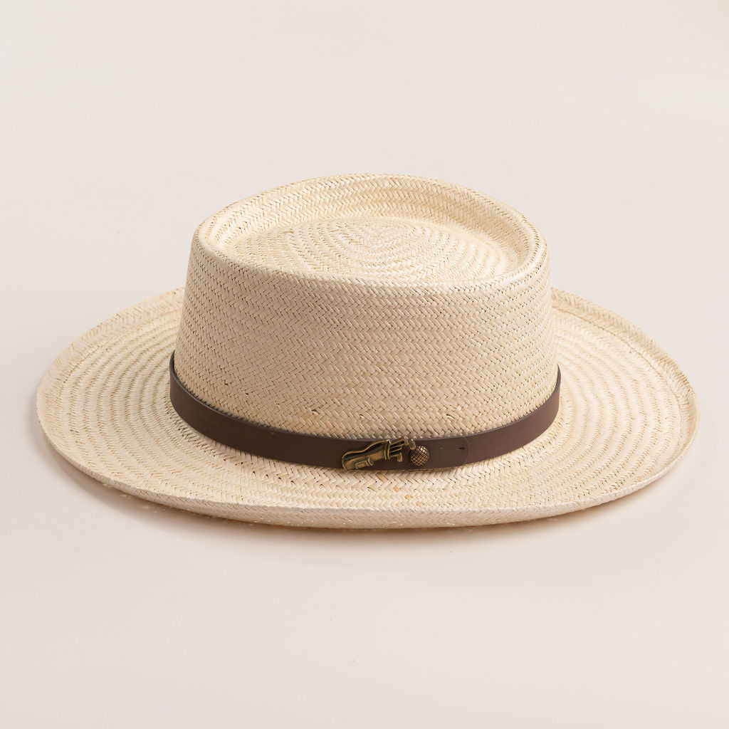 Natural colored straw hat with a brown band on a light beige background