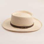 Natural colored straw hat with a brown band on a light beige background