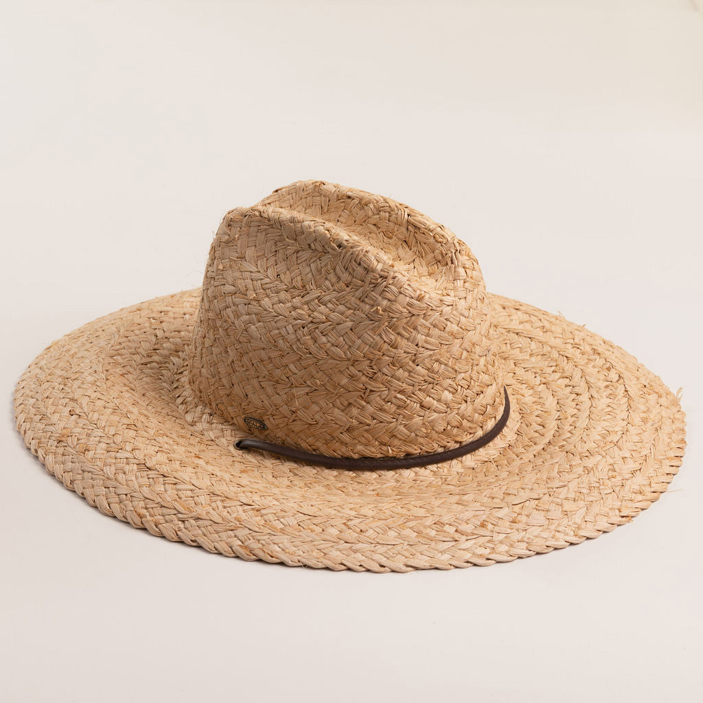 Natural colored straw hat with a wide brim on a light beige background