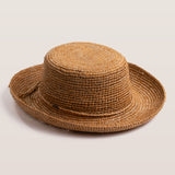 Tea colored straw hat on a light beige background