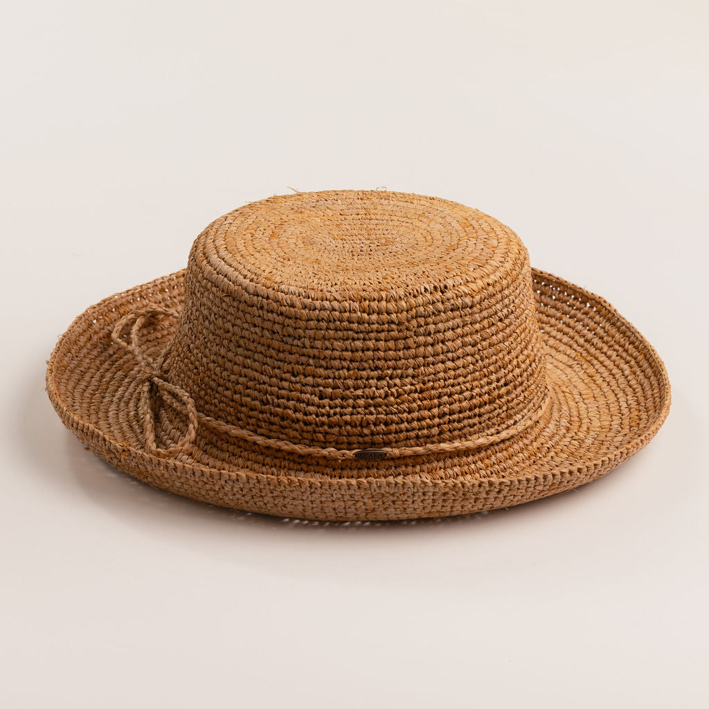 Tea colored straw hat on a light beige background