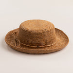 Tea colored straw hat on a light beige background