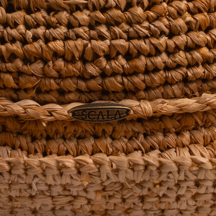 Close-up of a tea colored straw hat with the Scala logo pin