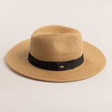 Toast colored straw hat with a black band on a light beige background