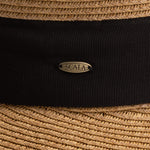 Close-up of a tea colored straw hat with a thick black band and Scala logo pin
