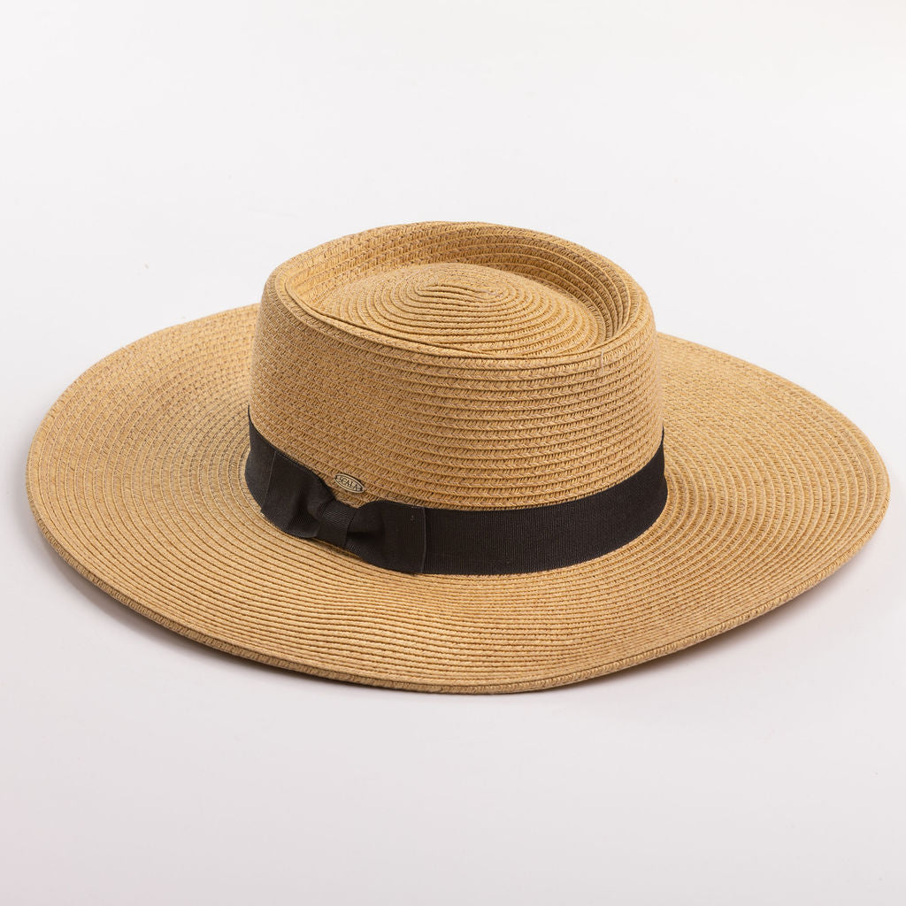 A natural straw sun hat with a black ribbon band and bow, photographed on a clean light gray background