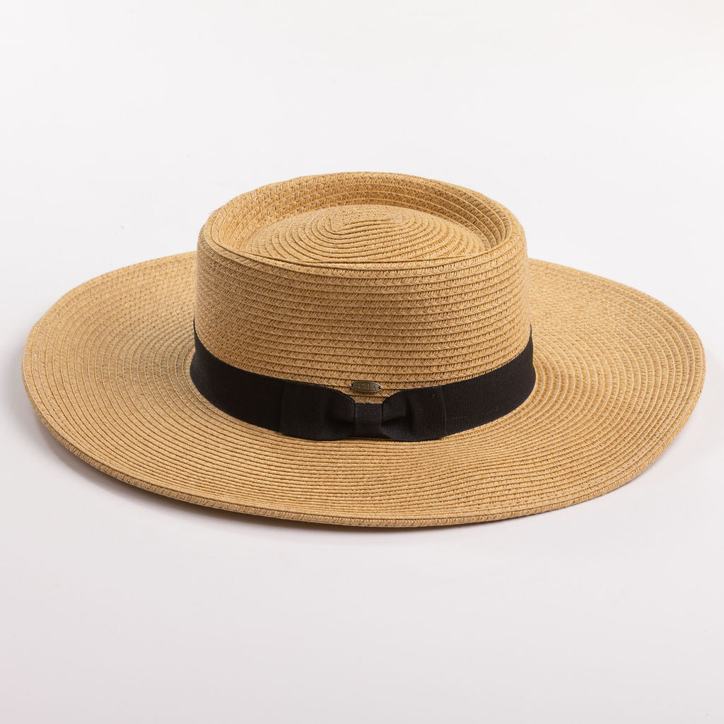 A natural straw sun hat with a black ribbon band and bow, photographed on a clean light gray background