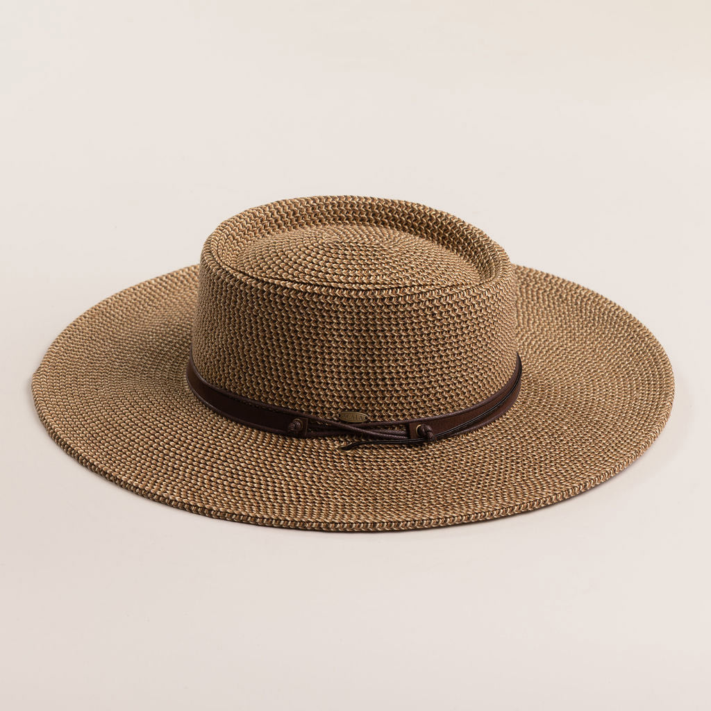 Brown straw hat with a wide brim on a light beige background