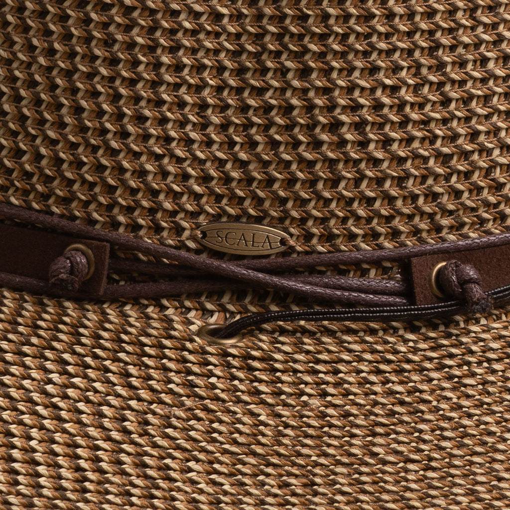 Close-up of a brown colored straw hat with the Scala logo pin and brown drawstring going into a golden colored eyelet