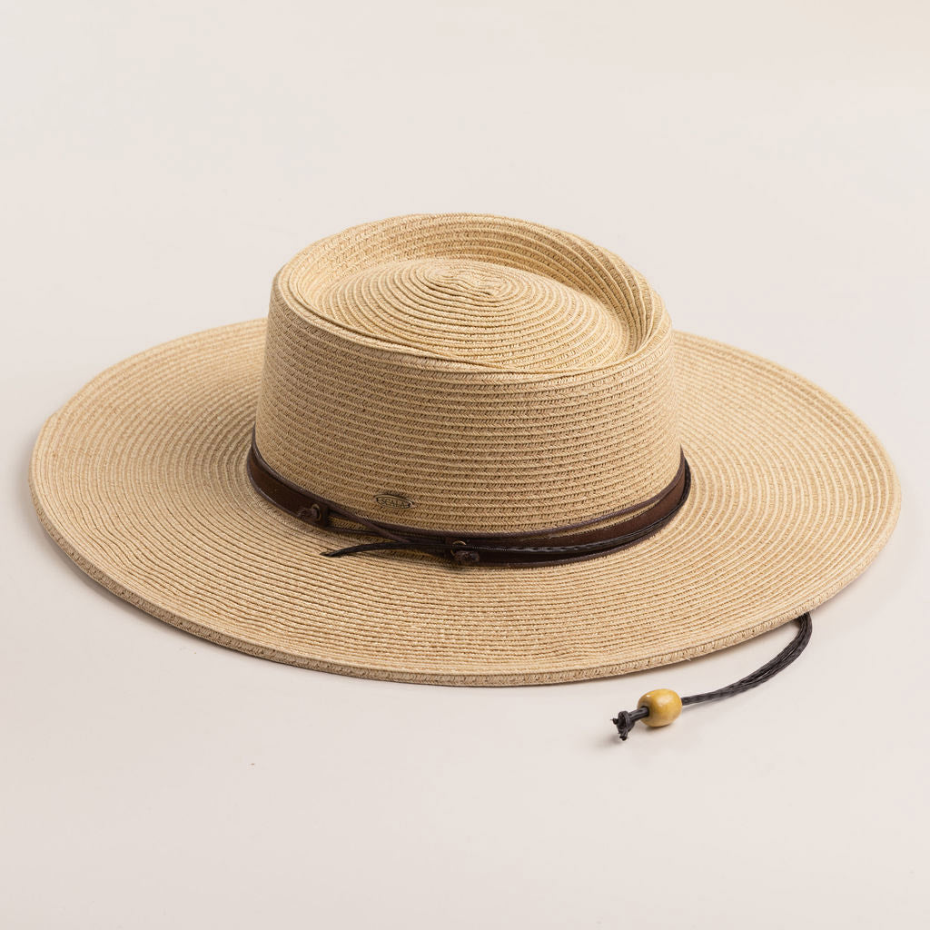 Natural colored straw hat with a brown band on a light beige background