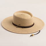 Natural colored straw hat with a brown band on a light beige background