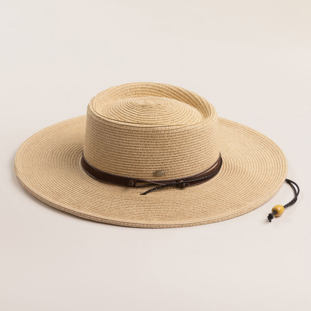 Natural colored straw hat with a brown band on a light beige background