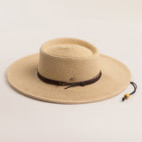 Natural colored straw hat with a brown band on a light beige background