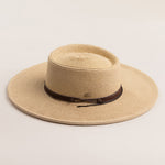Natural colored straw hat with a brown band on a light beige background