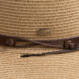 Close-up of a natural colored straw hat with the Scala logo pin and brown drawstring going into a golden colored eyelet