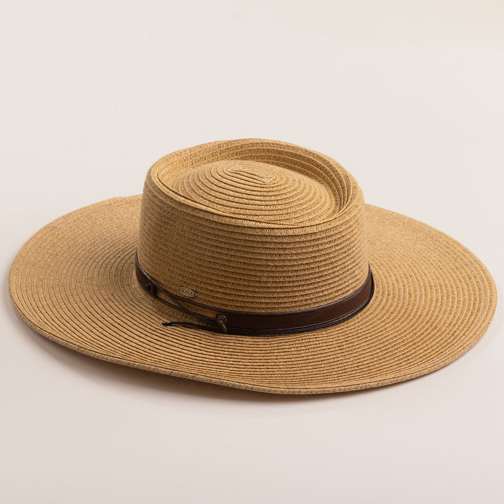 Toast colored straw hat with a brown band on a light beige background