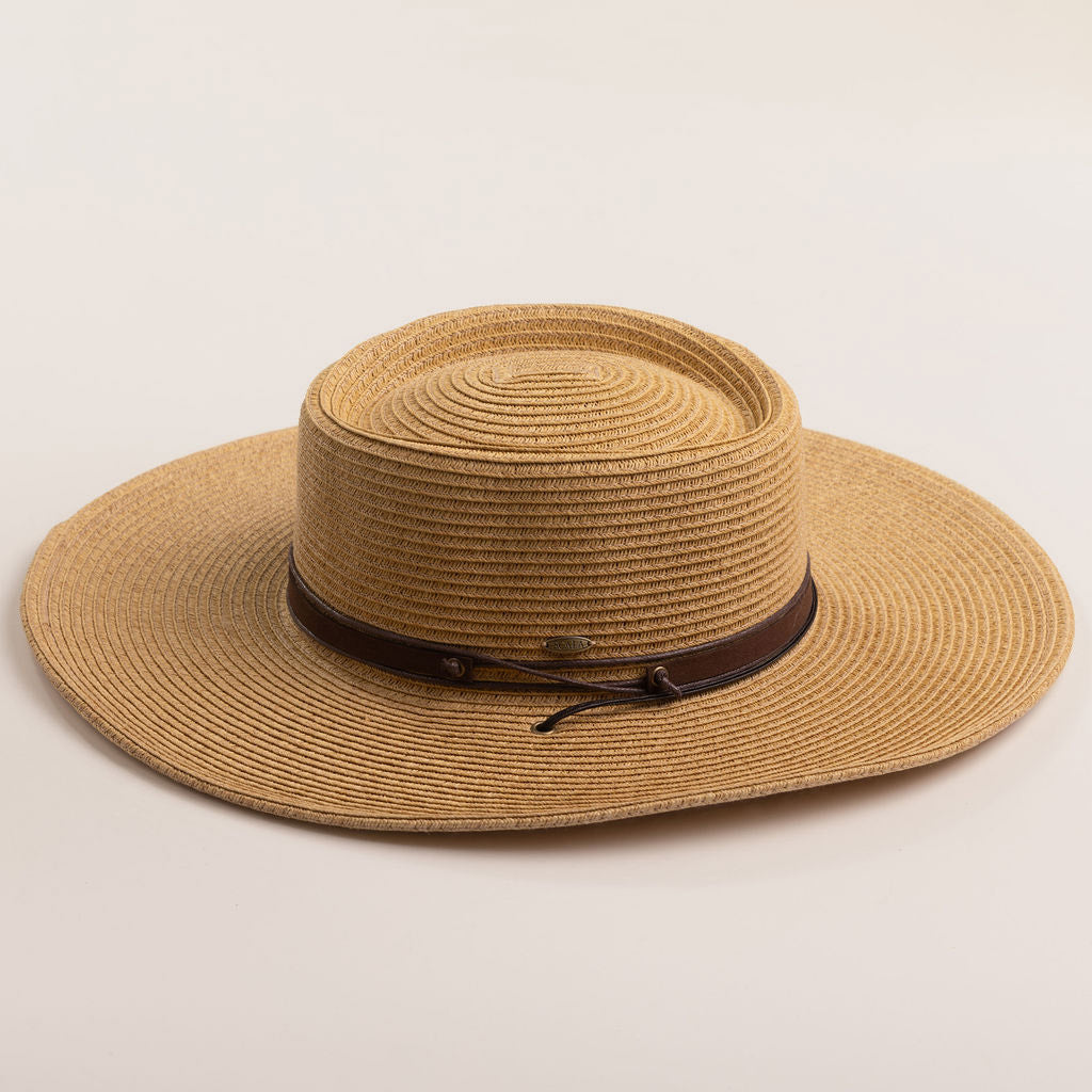 Toast colored straw hat with a brown band on a beige background