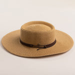 Toast colored straw hat with a brown band on a beige background