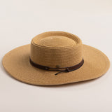 Toast colored straw hat with a brown band on a beige background