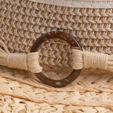 Close-up of a straw hat with a brown thick wooden buckle