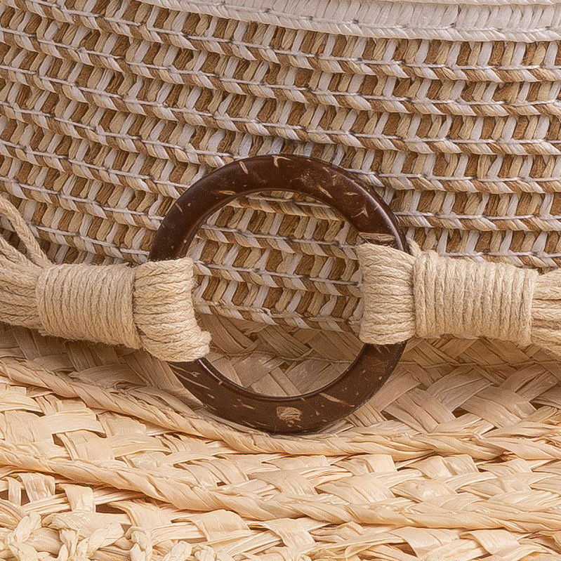 Close-up of a straw hat with a brown thick wooden buckle