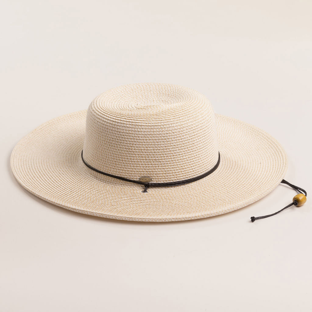 Ivory colored straw hat with a black band on a light beige background