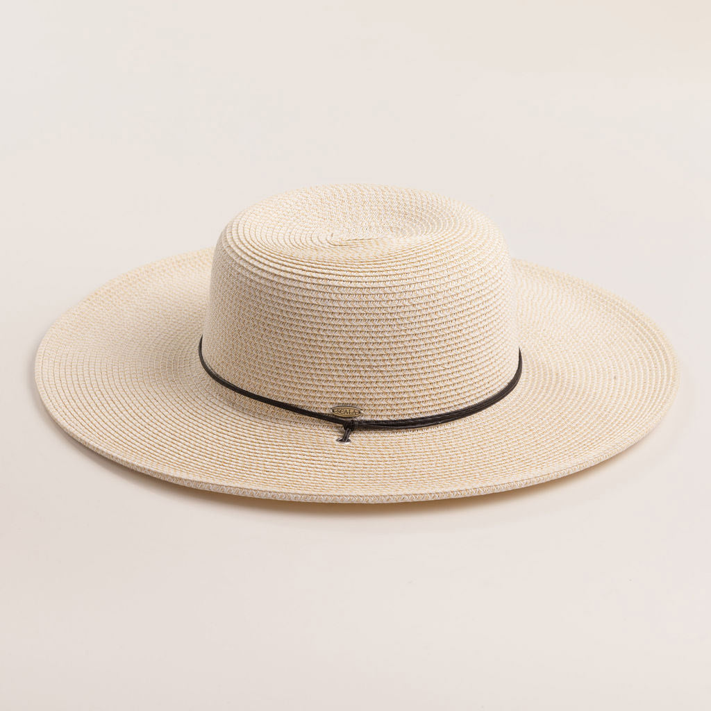 Ivory colored straw hat with a black band on a light beige background
