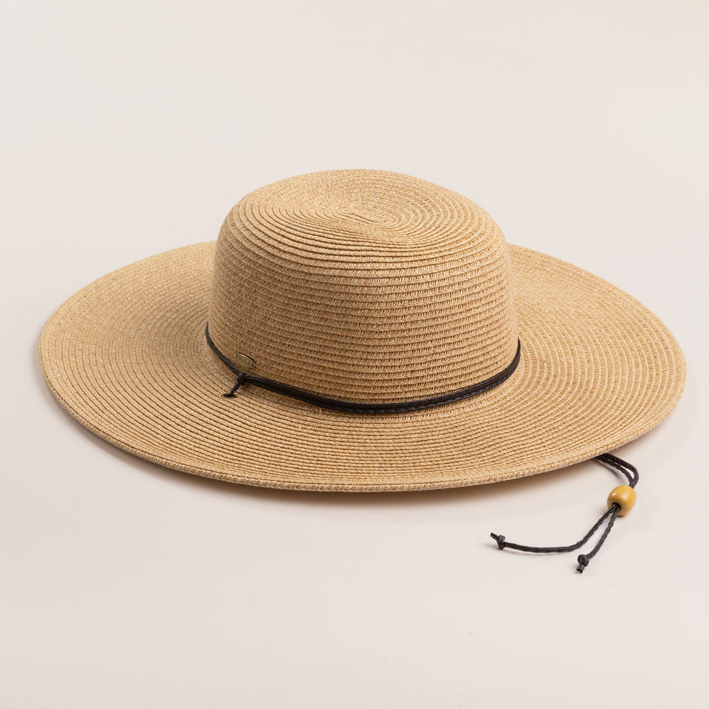 Natural colored straw hat with a wide brim on a light beige background