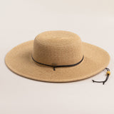 Natural colored straw hat with a wide brim on a light beige background