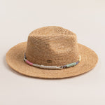 Natural colored straw hat with a colorful band on a light beige background
