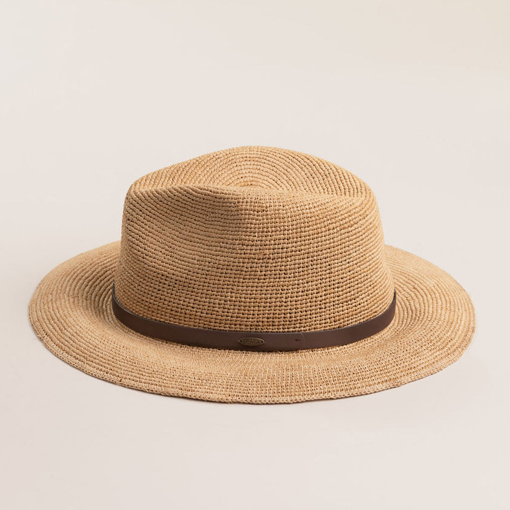 Natural colored straw hat with a brown band on a light beige background