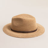 Natural colored straw hat with a brown band on a light beige background