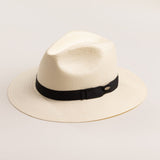 Natural colored straw hat with a black band on a light beige background
