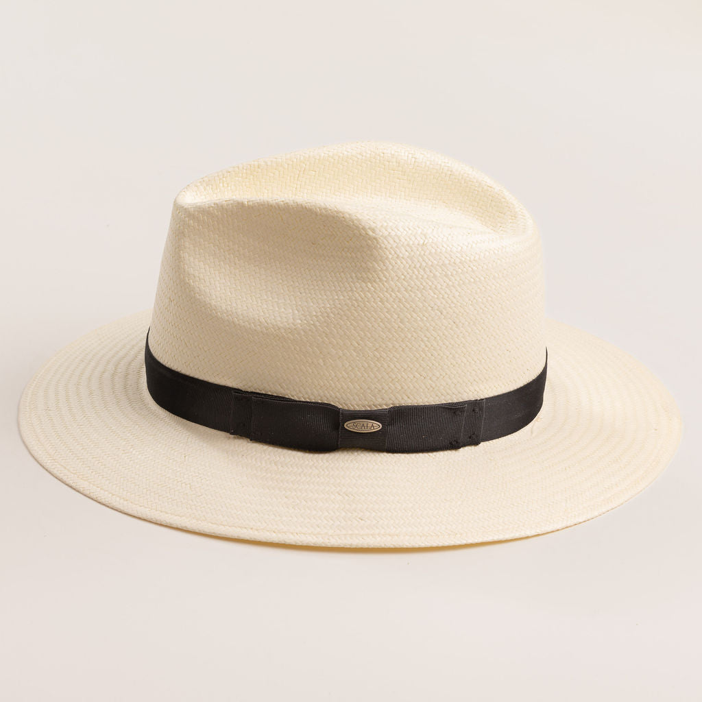 Natural colored straw hat with a black band on a light beige background
