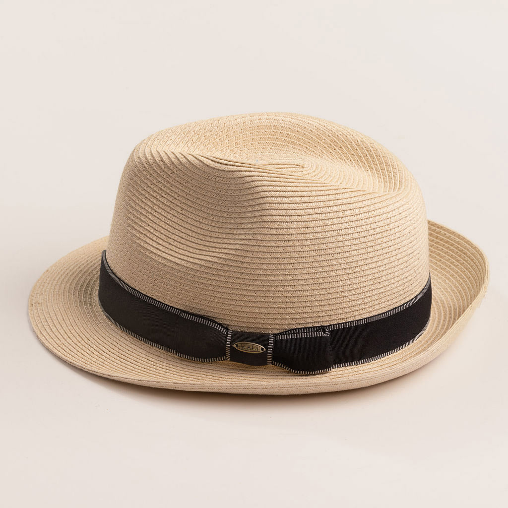 Natural colored straw hat with a black band on a light beige background