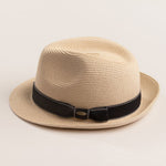 Natural colored straw hat with a black band on a light beige background