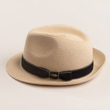 Natural colored straw hat with a black band on a light beige background