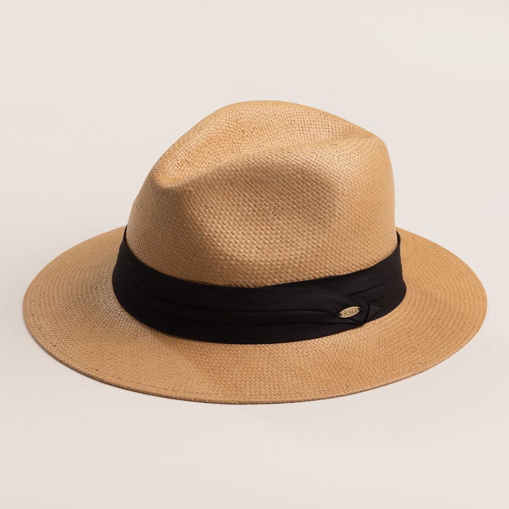 Putty colored straw hat with a black band on a light beige background