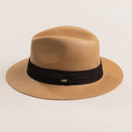 Putty colored straw hat with a black band on a light beige background