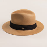 Putty colored straw hat with a black band on a light beige background