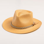 Putty colored straw hat with sandy colored braided band on a light gray background
