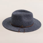 Denim colored straw hat with a brown band on a light beige background