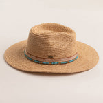 Natural colored straw hat with a decorative band on a light beige background