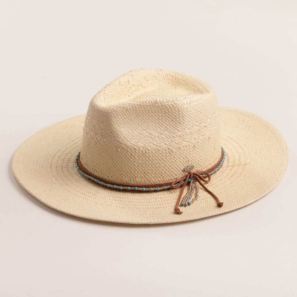 Natural colored straw hat with a decorative band on a light beige background