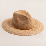 Natural colored straw hat on a light beige background
