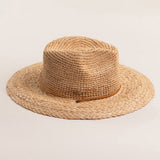 Natural colored straw hat with a wide brim on a light beige background