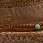 Close-up of a tea colored cowboy-shaped straw hat with braided band detail, turquoise bead, and Scala logo pin
